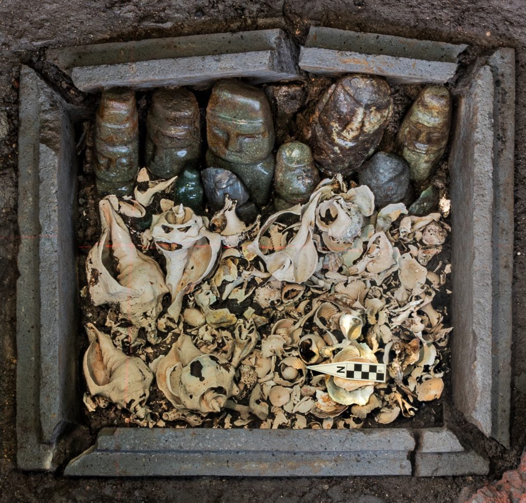 Arqueólogos hallan un cofre de piedra con 15 esculturas antropomorfas y numerosas cuentas de piedra verde, caracoles, conchas y corales marinos.